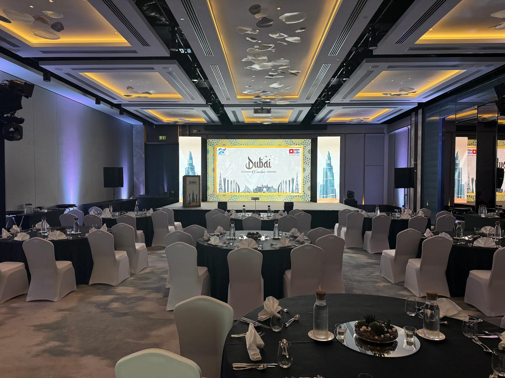 Banquet hall set with round tables facing a presentation stage