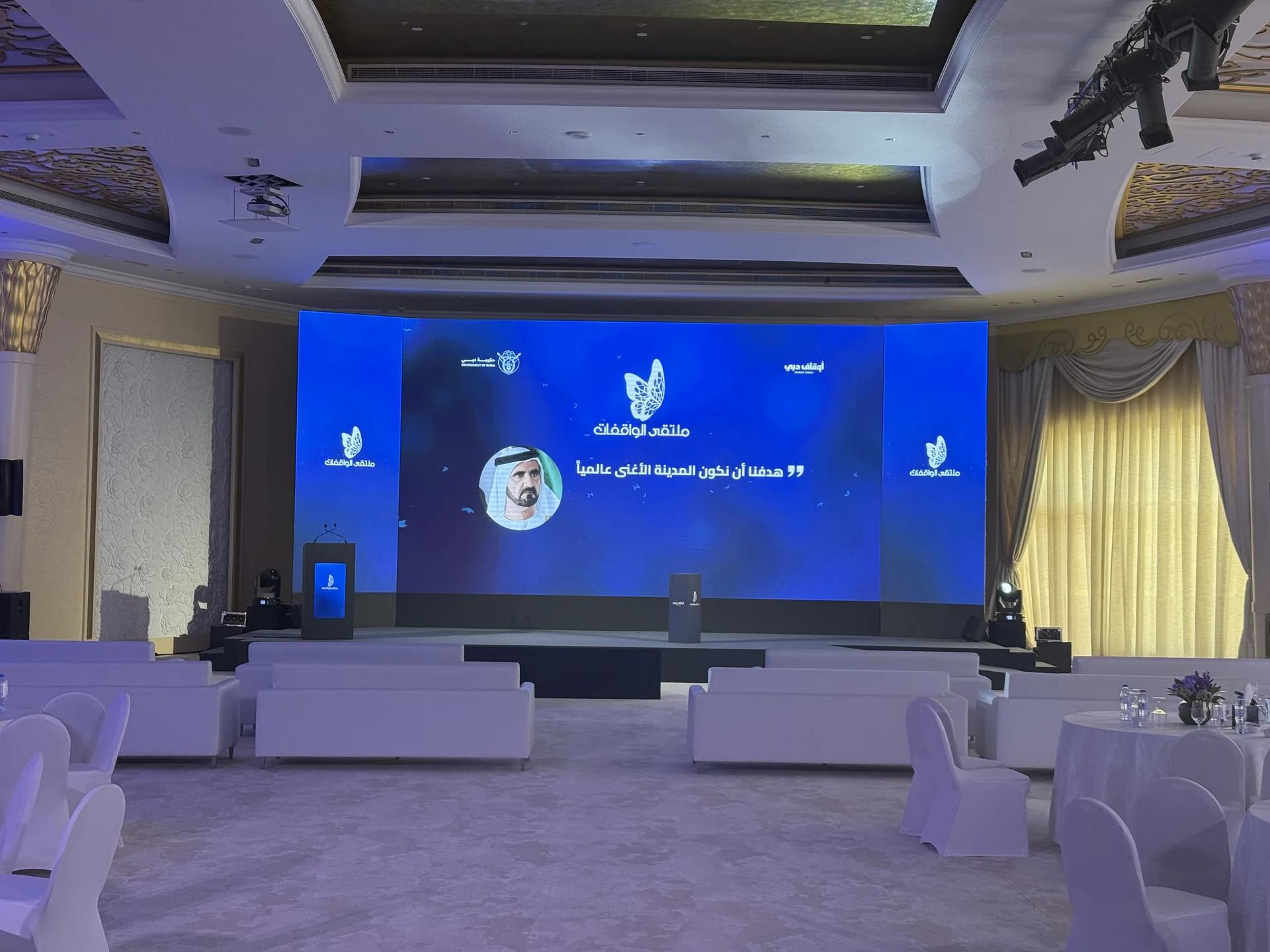 International conference stage with a wide LED screen and guest seating