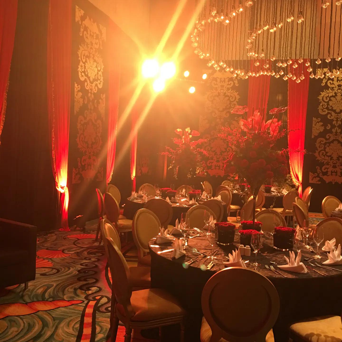 Private celebration room glowing with warm stage light and suspended décor.